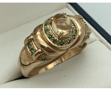 A 9ct gold dress ring set with citrine and tsavorite, by Gems TV. Central raised citrine cabochon surrounded by 14 small roun