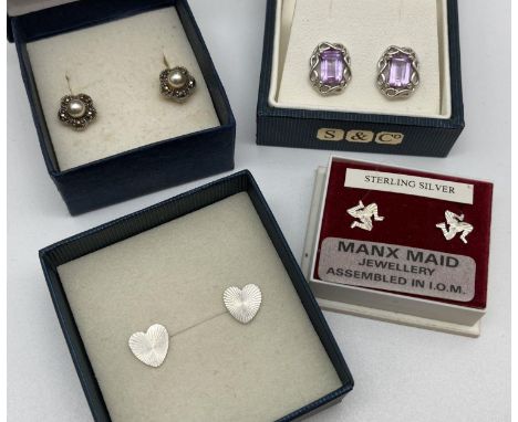 4 boxed pairs of silver earrings. A pair of heart studs with engine turned decoration, a pair of flower studs set with faux p