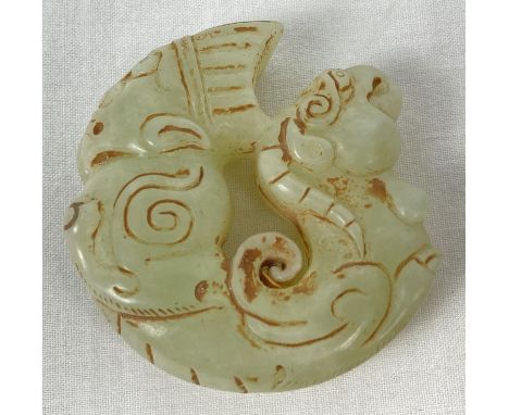 A carved jade roundel with mythical creature detail. Carved detail to both sides. Approx. 5.5cm diameter. 