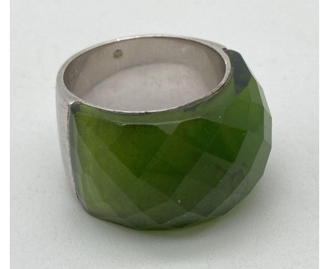 A large chunky dress ring with faceted green coloured stone. Stamped 925 inside band and flower shaped makers mark. Band widt