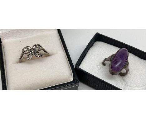 2 silver dress rings. A filigree style butterfly ring together with an oval cut amethyst cabochon set ring. Both marked 925 t