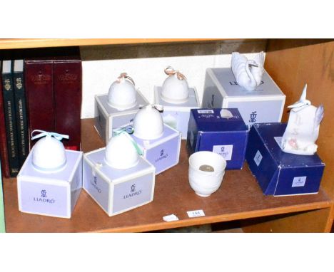 A collection of books relating to Lladro, Lladro bells, a swan and a plaque
