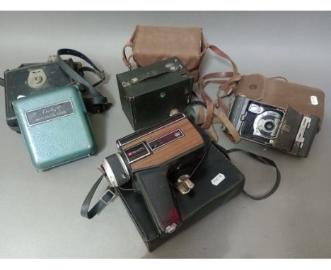 Two vintage cameras, an 8mm cine camera and a Cowley automatic level. 