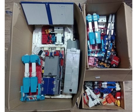 Two boxes containing vintage Transformers toys and a box of Go-Bots toys. 