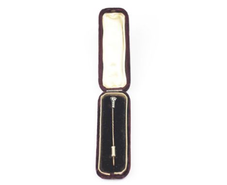 A diamond set stick pin, the terminal set with eight diamonds, all set in yellow and white metal, unmarked, within a fitted c