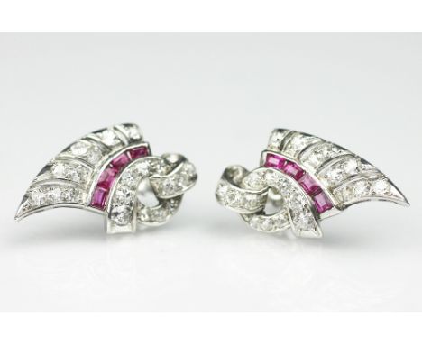 A pair of Art Deco diamond and ruby earrings, each of winged form and set with a central row of rubies, all set in white meta