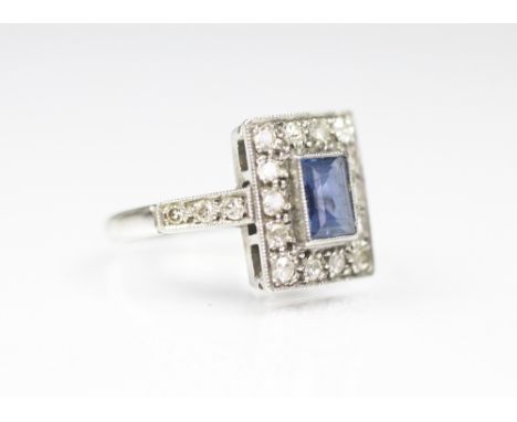 A sapphire and diamond rectangular cluster ring, the central sapphire (untested), collet set within a surround of eight-cut d