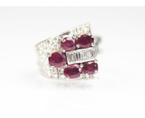 A ruby and diamond dress ring, London 1978, set with five oval cut rubies, within a diamond set tapering ground, all set in 1