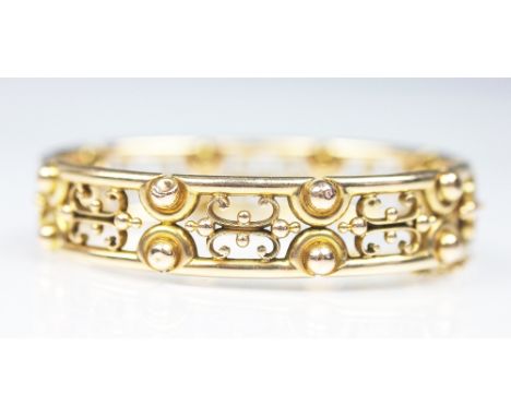 A 15ct yellow gold hinged bangle, early 20th century, with bead and scroll pierced design, integral clasp, stamped '15' and '