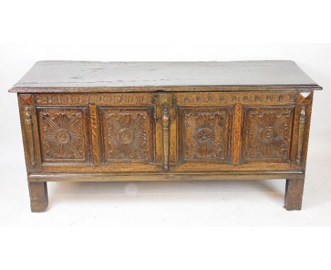A late 17th century and later carved oak coffer, with four panel front, on stile feet, 63cm H x 137cm W x 49cm D