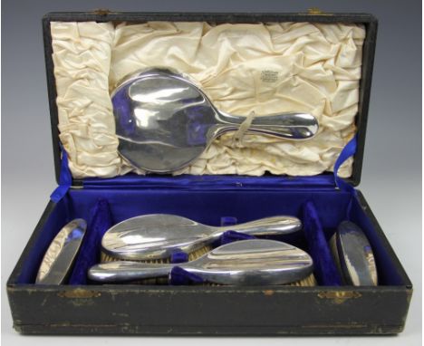 A cased silver backed dressing table set, Birmingham 1918, each piece of plain polished form, comprising; hand mirror, two ha