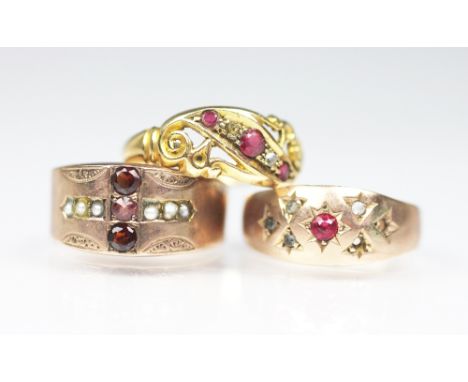 A ruby and diamond ring in 18ct yellow gold, a garnet and seed pearl ring stamped '333' and a further ring in 9ct gold, total