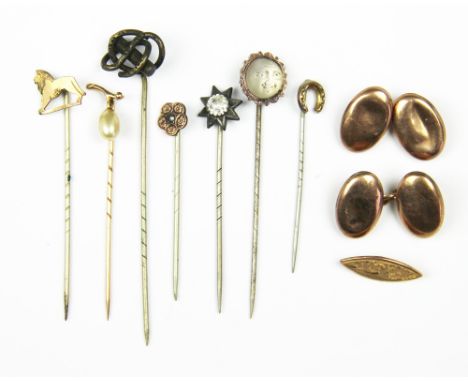 A selection of seven stick pins, to include; a cast 'man in the moon' example, a 'pearl' set stick pin stamped '375', a horse