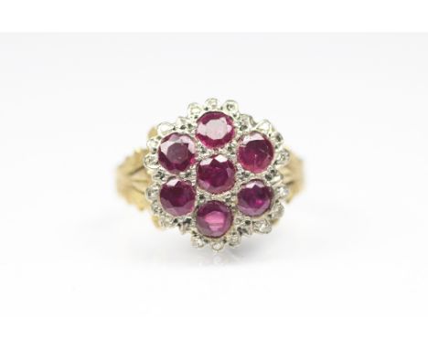 A ruby and diamond cluster ring, 19th century, the seven circular rubies within diamond set surround and foliate carved hoop,