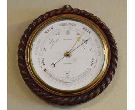 Early 20th Century oak circular aneroid barometer and thermometer, the case with carved rope twist decoration, the white enam