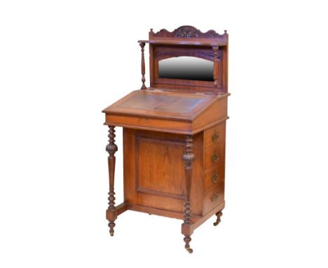 Late Victorian walnut davenport, the raised back fitted an open shelf supported by turned pilasters, bevelled mirror panel be