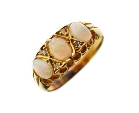 Three stone opal ring, the stones interspersed by diamond points, unmarked yellow metal shank, size K   Condition: 