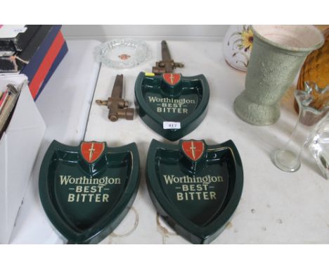Three Worthington Best Bitter advertising ashtrays, a Tetley glass advertising ashtray and two brass barrel taps