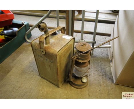A small hanging oil lantern and a small paraffin fuel can