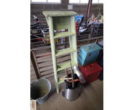 A wooden five step folding ladder and a pedal bin with contents of various items