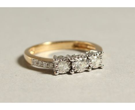 A 9CT GOLD THREE STONE DIAMOND RING.