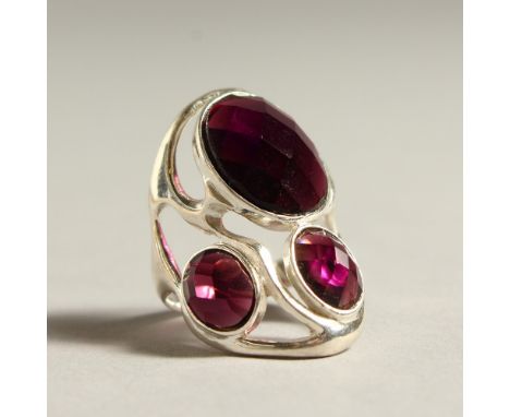 A SILVER THREE STONE AMETHYST RING.