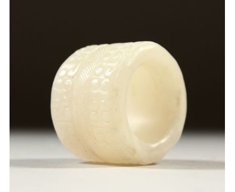 A WHITE JADE ARCHERS RING. 3cms wide.