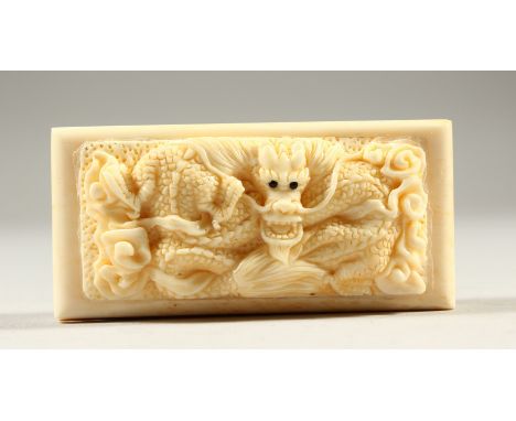 A BONE RECTANGULAR SNUFF BOX AND COVER, the lid carved with a dragon. 7cms long.