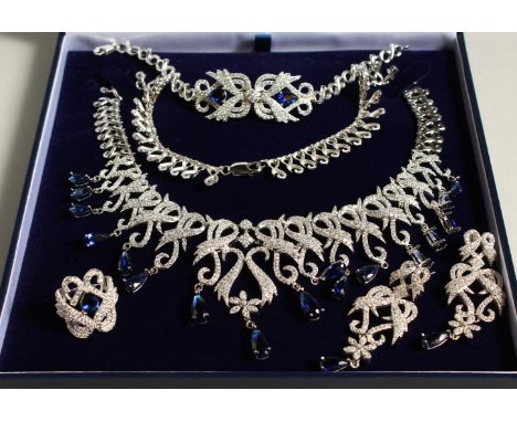 A SILVER AND FAUX SAPPHIRE FOUR PIECE SET, necklace, ring and earrings.