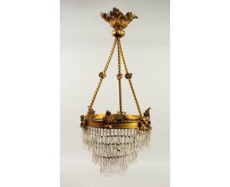 A 19TH/20TH CENTURY ORMOLU HANGING LIGHT FITTING, with three tiers of cut glass prism drops. 62cms high x 28cms wide.