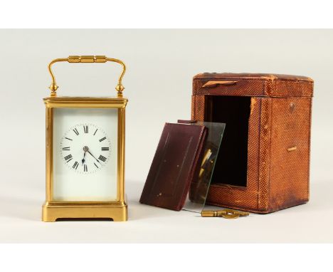 A 19TH CENTURY FRENCH BRASS CARRIAGE CLOCK, in a leather case. 15cms high.