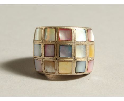 A SILVER RING inset with coloured panels.