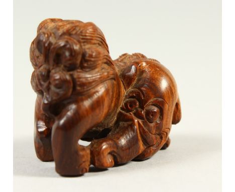 A CARVED WOOD NETSUKE OF A TEMPLE LION. 4cms long.
