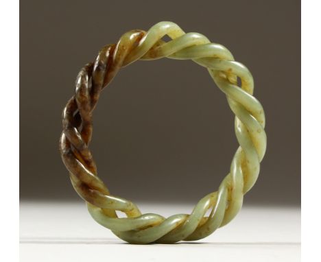 A GREEN JADE TWISTED BANGLE. 8cms diameter.