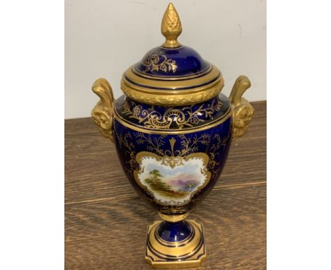 A Coalport porcelain lidded urn vase, decorated in Cobalt  blue with gilt scrolls and a painted landscape. W:8cm x D:8cm x H: