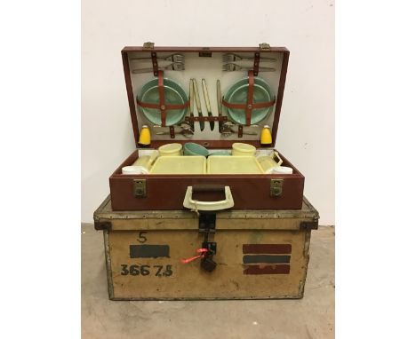 A vintage trunk with a near complete Thermos picnic set.