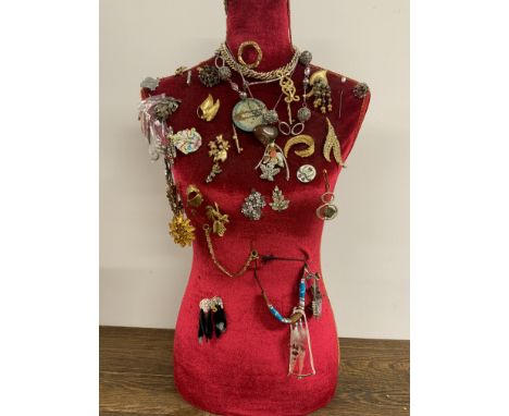 An upholstered mannequin with jewellery.
