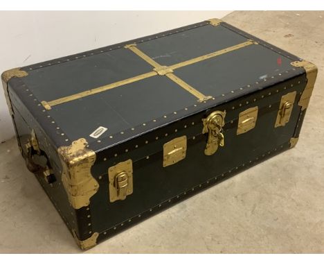 A fitted brass bound travelling trunk with leather handles and a key.W:92cm x D:53cm x H:35cm