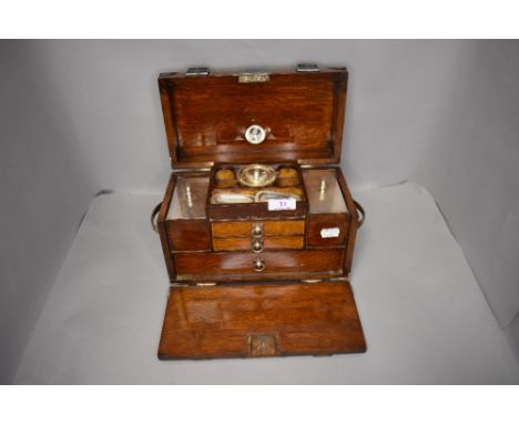 A late Victorian portable tea caddy having fitted compartments and storage drawers with spirit in oak case
closed, measures a