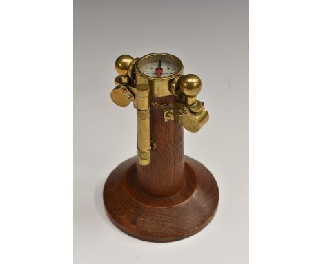 An oak and brass novelty desk model, of a ship's compass, circular base, 13cm high