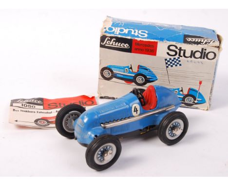 An original vintage Schuco made Studio 1050 Mercedes tinplate clockwork racing car. Blue, with red interior. With original in