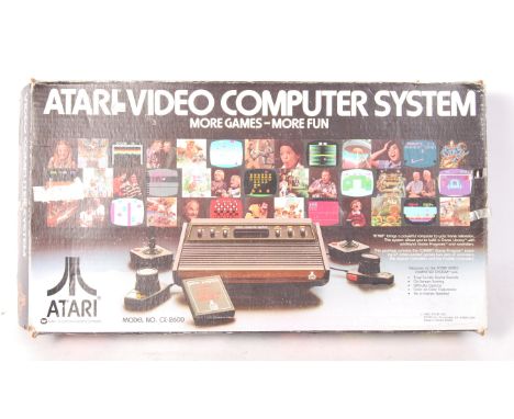 An original vintage Atari CX - 2600 ' Video Computer System '. Comprising: the console unit, two joystick controllers, TV lea
