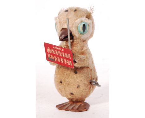 A vintage 1950's / 1960's ' Made In Japan ' tinplate clockwork ' Conducting Bird ' toy. Fur covered tin, with tinplate eyes, 