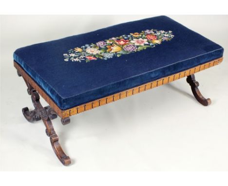 An early Victorian rosewood framed stool with rectangular upholstered floral tapestry top above a deep notched frieze and rai
