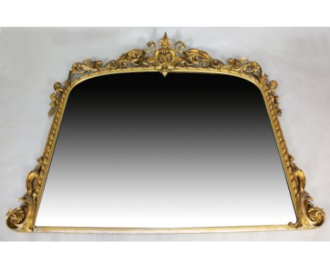 A large Victorian gilt gesso framed overmantel mirror, circa 1860, the arched plate within a bead and ribbon border and surmo