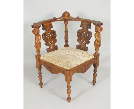 A walnut corner desk chair, 19th century, the foliate carved top rail surmounted by a central cherub mask bracket above a fol