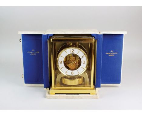 A Jaeger-le-Coultre Atmos clock the five glass gilt metal case containing a white dial with Arabic numerals, North, South, Ea