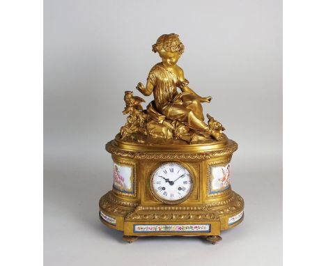 A French gilt metal and porcelain mounted mantel clock, by Le Roy et Fils, the rounded rectangular case surmounted by a child