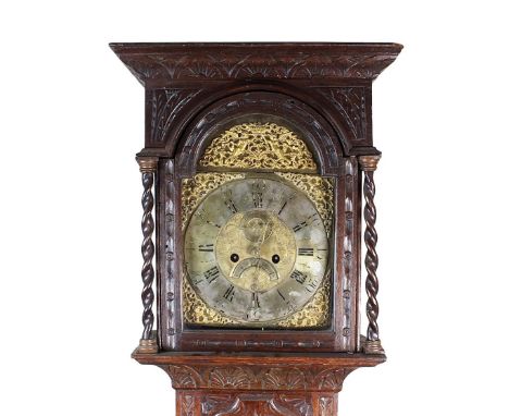 A George III oak longcase clock, later carved, the ogive moulded cornice, lunette carved above an arched glazed door flanked 