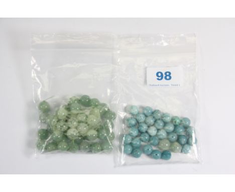 A quantity of loose pale blue jade / hardstone beads and a further quantity of green jade beads